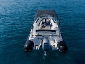 Aerial view of a sleek center console boat cruising through clear blue waters, perfect for day trips and water adventures.