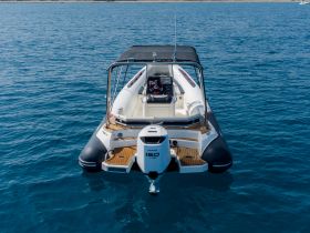 A sleek speedboat captured from the front, showcasing its design and structure against a vibrant blue sea, perfect for thrilling water adventures.