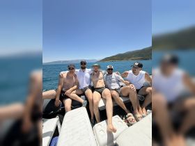 A group of friends enjoys a sunny day on the water, relaxing on a boat and making memories together — perfect for summer outings and celebrations.