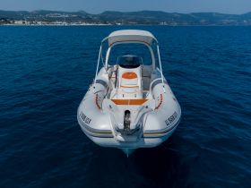 A sleek speedboat captured from the front, gliding through clear blue waters, perfect for a day of adventure on the sea.