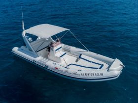 Aerial view of a sleek speedboat gliding through clear blue waters, showcasing its elegant design and spacious seating — perfect for thrilling water adventures.