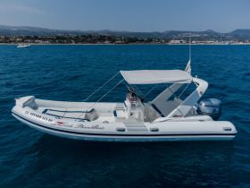 Aerial view of a sleek speedboat anchored in clear blue waters, showcasing its elegant design and perfect for leisure outings.