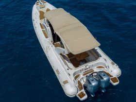 Aerial view of a sleek speedboat cruising through deep blue waters, showcasing its elegant design and spacious deck, perfect for thrilling adventures on the sea.