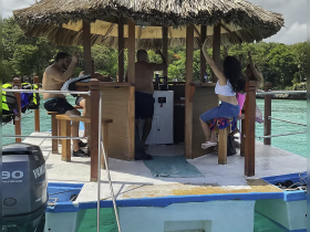 A lively group enjoys drinks and fun at a boat bar, capturing the essence of a perfect day on the water.