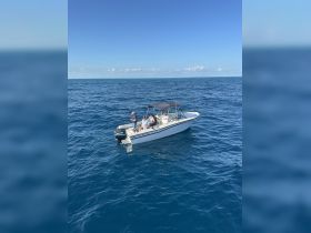 A group of friends enjoys a fishing trip on a boat in the open ocean, showcasing the thrill of adventure on the water.