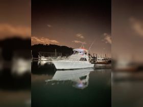 A stunning night view of a yacht docked at the marina, beautifully reflecting in the calm waters — perfect for showcasing luxury boating experiences.