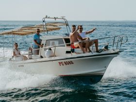 A lively group enjoys a fun day on the water, cruising aboard a boat and celebrating with smiles and waves — perfect for summer adventures.