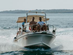 A lively group enjoys a day on the water, cruising on a boat and soaking up the sun — perfect for summer adventures and memorable outings.