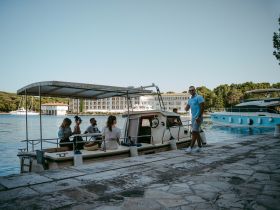 A group of friends enjoys their time on a boat at the harbor, capturing the essence of a fun day out on the water.