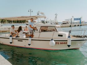 A group of friends enjoys a sunny day aboard a boat at the dock, perfect for a relaxing outing on the water.