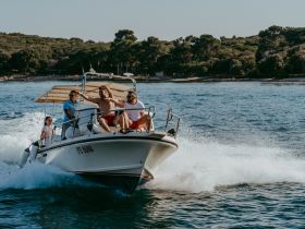 A lively group enjoys a thrilling ride on a speedboat, capturing the essence of summer fun on the water.