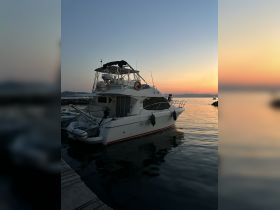 A serene view of a yacht docked at sunset, reflecting beautifully on the calm waters — perfect for evening cruises and relaxation.