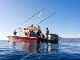 A lively group enjoys a fishing trip on a boat, showcasing the excitement of ocean adventures with friends and family.