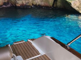 A serene view from the interior of a boat, showcasing the beautiful turquoise waters and rocky surroundings, perfect for a relaxing day on the water.