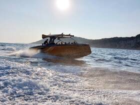 A sleek speedboat cuts through the waves under the sun, showcasing an exhilarating day on the water with friends or family.