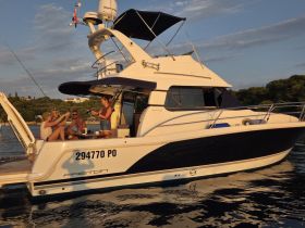 A lively group enjoys drinks and laughter aboard a yacht, capturing the essence of a perfect day on the water with friends.