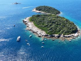 A stunning aerial view of two lush islands surrounded by crystal-clear waters, showcasing the beauty of the coastline and perfect for exploring by boat.