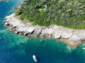 A stunning aerial view of a secluded island coastline with crystal-clear turquoise waters, perfect for exploring and enjoying nature's beauty.