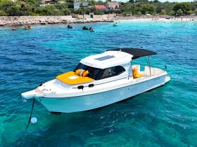 A stunning view of a sleek yacht anchored in crystal-clear waters, showcasing its elegant design and inviting sunbathing area — perfect for summer adventures.
