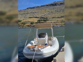 A sleek speedboat docked along a serene waterfront, showcasing its stylish design and inviting atmosphere for a day on the water.