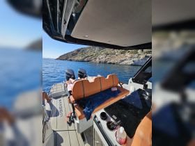 A cozy interior view of a boat featuring comfortable seating and a helm area, perfect for relaxing while enjoying the scenic coastal waters.