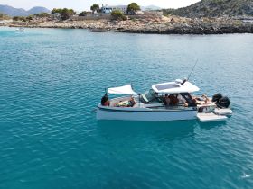 A lively group enjoys a day on the water aboard a stylish boat, soaking up the sun and relaxing in the stunning turquoise waters.