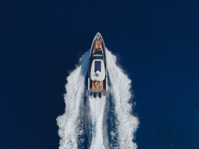 Aerial view of a speedboat cruising through deep blue waters, showcasing the thrill of adventure on the open sea.