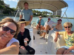 A cheerful group of friends enjoys a day on the water, capturing memories aboard their boat. Perfect for celebrating special moments or simply enjoying the sun.