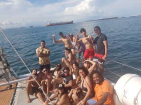 A lively group enjoys a fun day on the water, posing together on a boat with the ocean backdrop — perfect for celebrations and memorable outings.