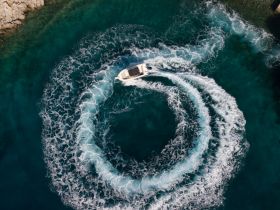 Aerial view of a boat making sharp turns in vibrant turquoise waters, showcasing the excitement of on-water activities.