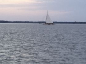 A blurry image of a sailboat on the water, making it difficult to discern details or context.