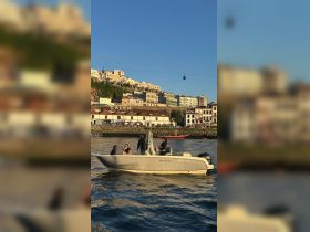 A lively group enjoys a boat ride along the waterfront, with stunning city views in the background — perfect for exploring the scenic coastline.