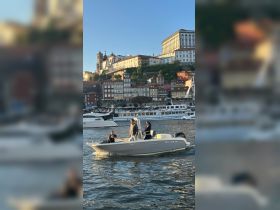 A group enjoys a scenic boat ride along the waterfront, with stunning city views in the background — perfect for exploring the vibrant atmosphere of the area.