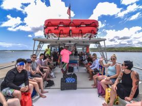 A lively group of guests enjoys their time aboard a boat, waving and sharing smiles, perfect for a fun-filled tour experience on the water.
