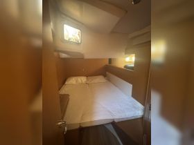 Cozy cabin interior featuring a comfortable double bed, perfect for restful nights on the water.