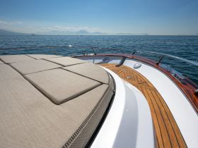 A close-up view of the luxurious lounge area on a boat, showcasing comfortable seating and elegant wooden details, perfect for relaxing on the water.