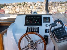 A detailed view of the helm and console of a luxury boat, showcasing advanced navigation instruments and controls, perfect for a smooth sailing experience.