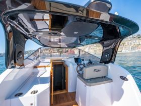 A sleek interior view of a boat's helm area, showcasing modern design elements and a comfortable seating arrangement, perfect for navigating the open waters.