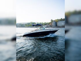 A sleek speedboat glides through the water with a person at the helm, showcasing the thrill of boating on a sunny day.