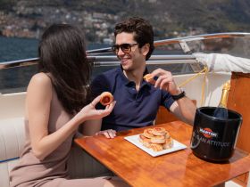 A couple enjoys a delightful snack and champagne on a boat, perfect for romantic outings or special celebrations on the water.