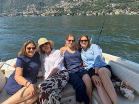 A group of friends enjoys a sunny day on a boat, capturing the essence of relaxation and camaraderie on the lake.