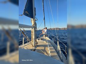 A man enjoys sailing on a sunny day, showcasing the beauty of the ocean and the thrill of being on a boat.