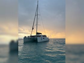 A serene view of a catamaran anchored in calm waters at sunset, showcasing the beauty of sailing adventures.