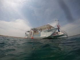 A lively scene aboard a boat with guests enjoying the water, showcasing the fun and excitement of a day on the ocean.