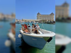 A lively group gathers on the boat 'Elisabetta II', enjoying a sunny day on the water — perfect for group outings and celebrations.