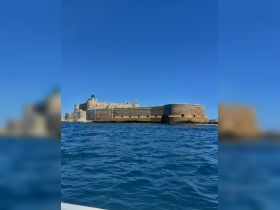 A stunning view of a historic fortress against a clear blue sky, showcasing the beauty of coastal landmarks — perfect for sightseeing and exploration.
