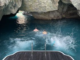 A couple enjoys a refreshing swim in a stunning cave, surrounded by crystal-clear waters — an unforgettable adventure in nature.