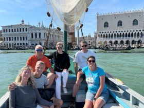 A cheerful group enjoys a scenic boat ride through the canals of Venice, capturing the essence of sightseeing in this iconic city.