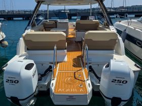 The interior of the Aquila boat showcases spacious seating and a well-designed helm area, perfect for comfortable cruising and relaxation on the water.