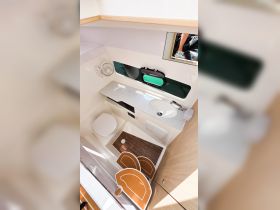 A well-designed interior view of a boat's bathroom, featuring modern amenities and ample storage, perfect for comfort on the water.
